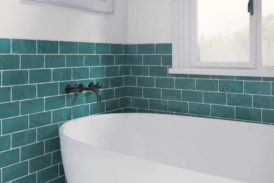 teal glossy subway tile in white bathroom surrounding deep soak tub